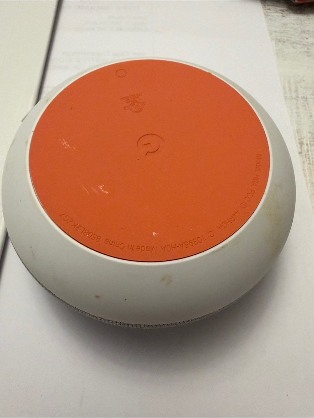 google smart speaker with white body and orange base